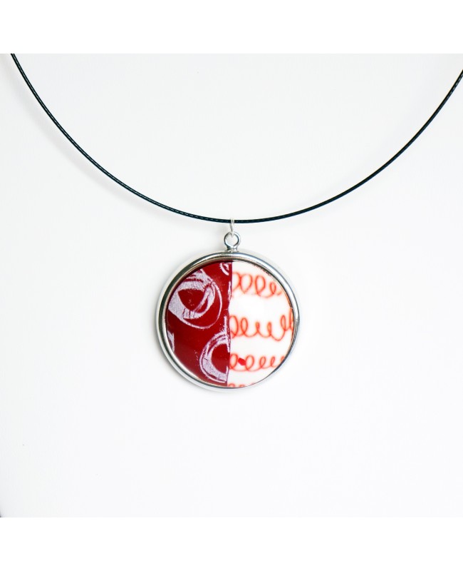 Pendentif rond rouge avec des ronds et des spirales