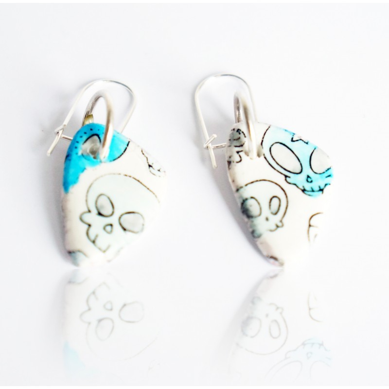 White earrings with blue skulls