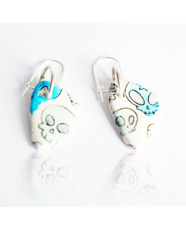 White earrings with blue skulls