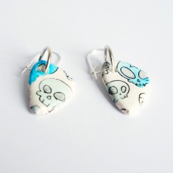 White earrings with blue skulls