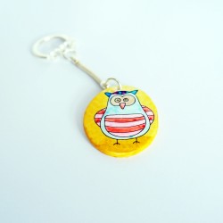 Blue and red owl keychain on a yellow background