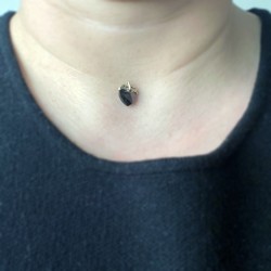 A small black heart pendant with a nylon cord